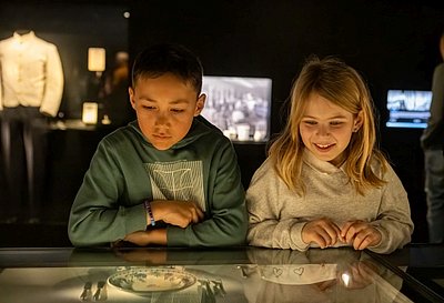 Kinder vor Vitrine in Ausstellung