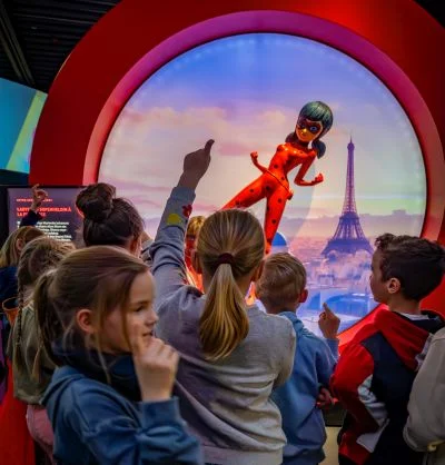 Kinderführung 2024: Kinder mit Lady Bug Figur vor Eifelturmbild © VKR