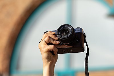 Eine Kamera wird in die Luft gehalten, bereit zum Fotografieren.