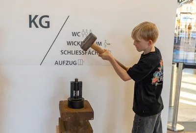 Junge mit Hammer Ausstellung Lokschuppen Rosenheim Ausstellung Römer 2026 Copyright Axel Jusseit